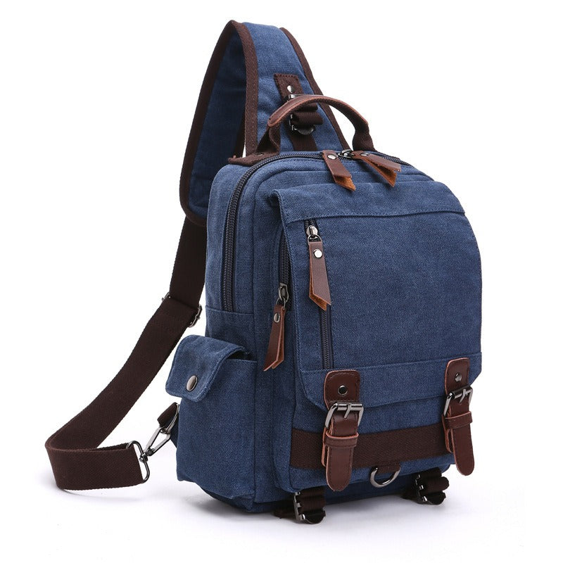 Blue canvas backpack with front flap pocket, zip compartment, and adjustable shoulder strap