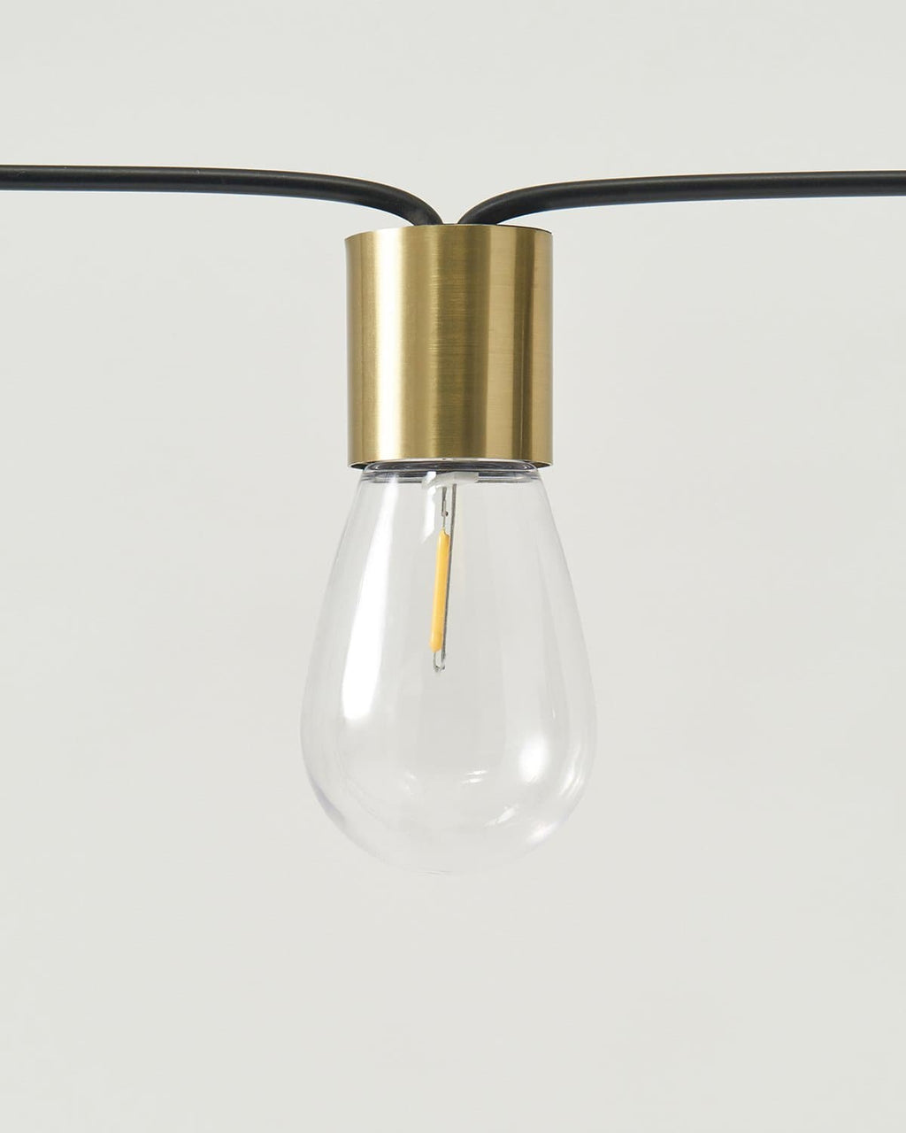 Solar string light bulb with gold socket and clear glass globe on black cord