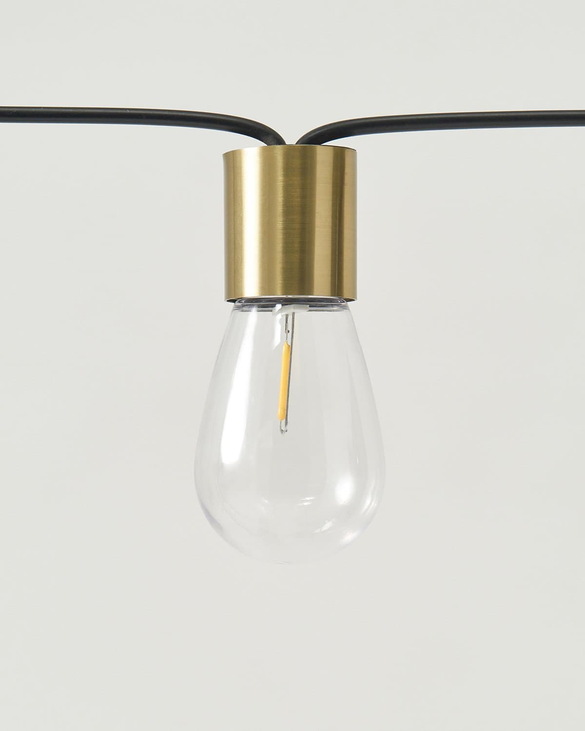 Solar string light bulb with gold socket and clear glass globe on black cord