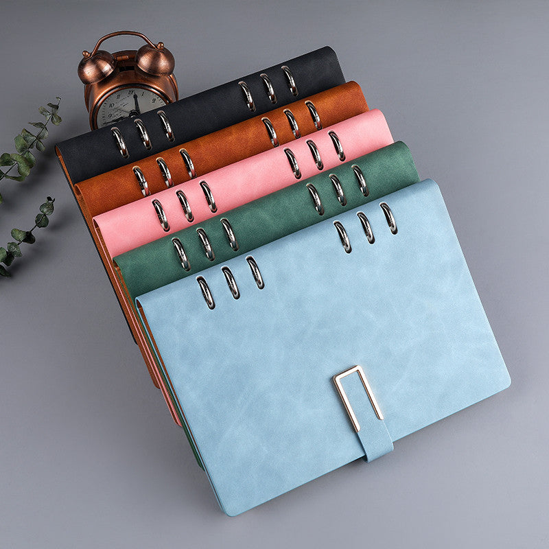 A5 loose-leaf notebook with metal rings and buckle, shown in mixed colors