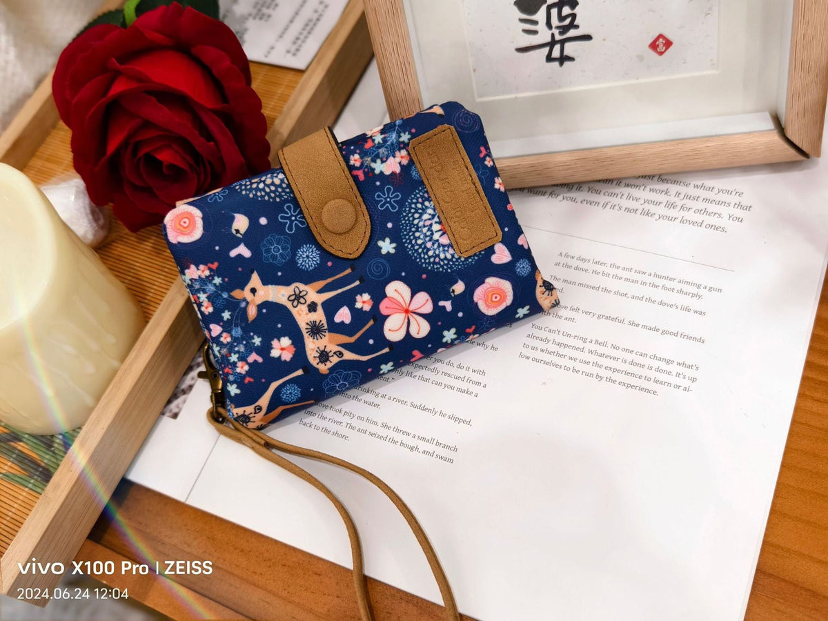 Printed tri-fold wallet with snap button and wrist strap, navy flower animal pattern