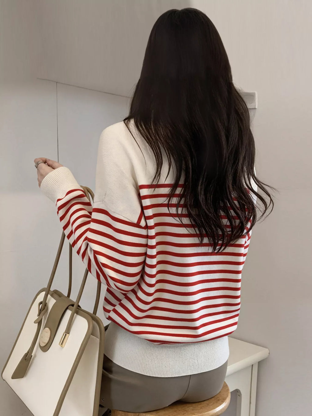 Red-and-white striped knit long-sleeve top, buttoned V-neck placket on back view