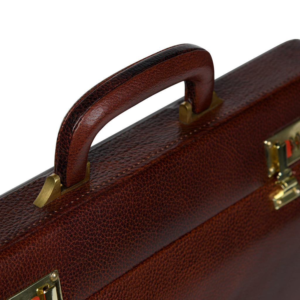 Close-up of rich brown leather suitcase carry handle with textured finish
