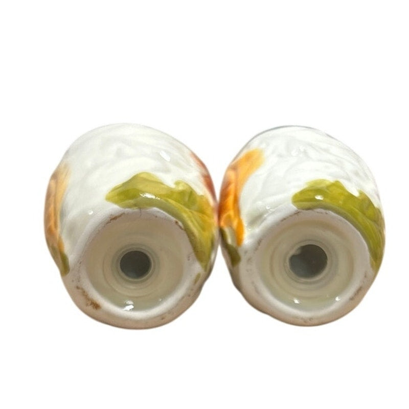 Ceramic salt and pepper shaker set, bottom view of white shakers with leaf print