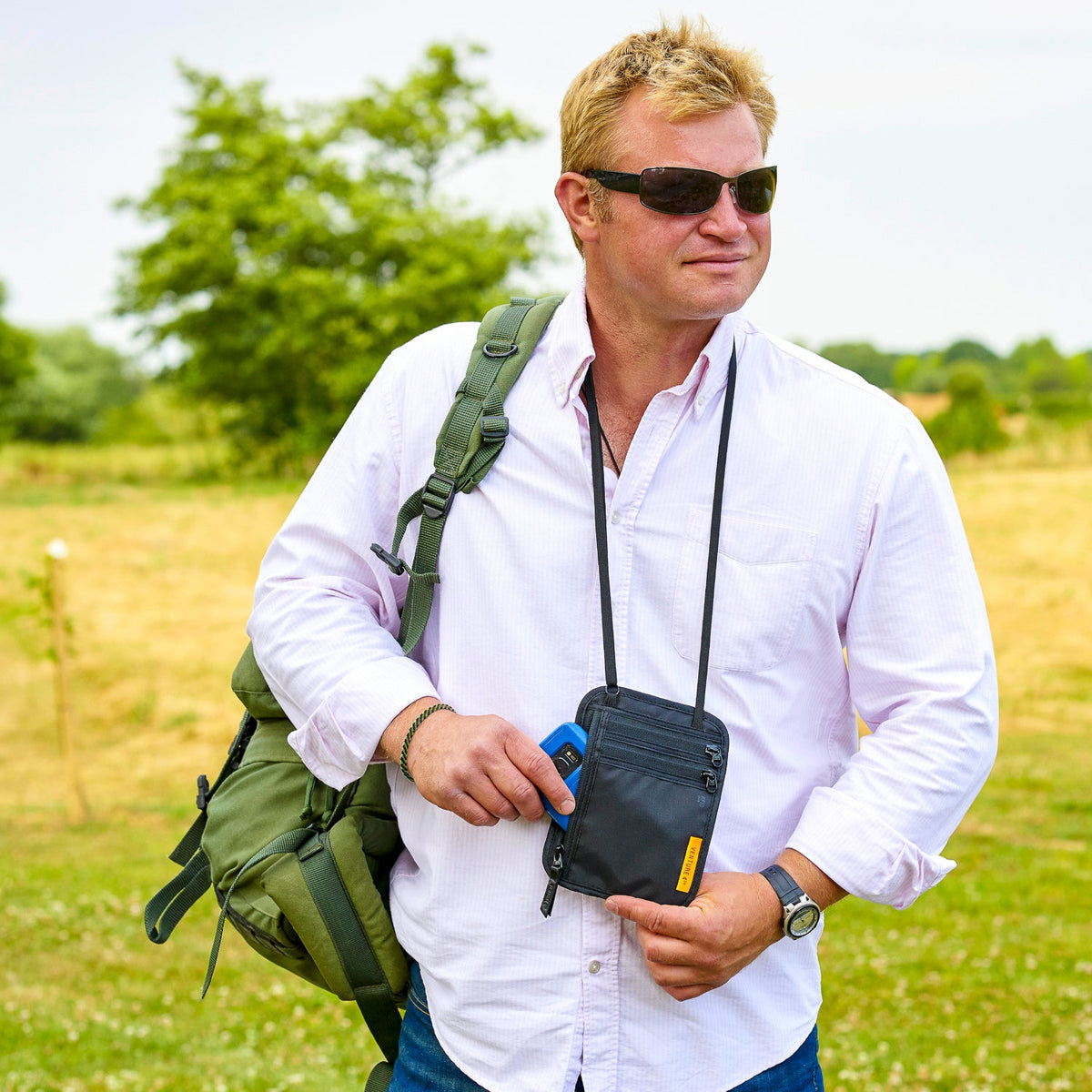 Navy slim travel neck wallet with zip front and adjustable strap worn crossbody.
