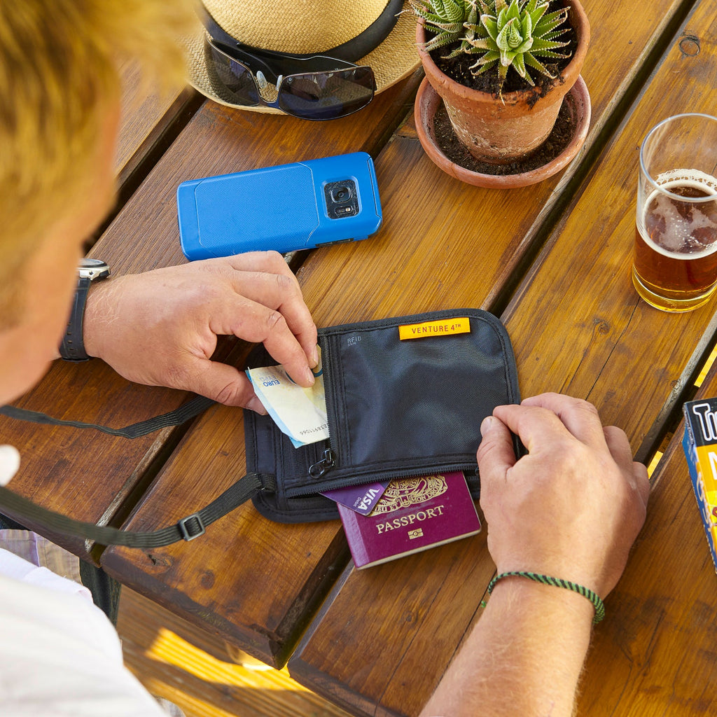 Blue slim travel neck wallet with open zip pocket and card slots.
