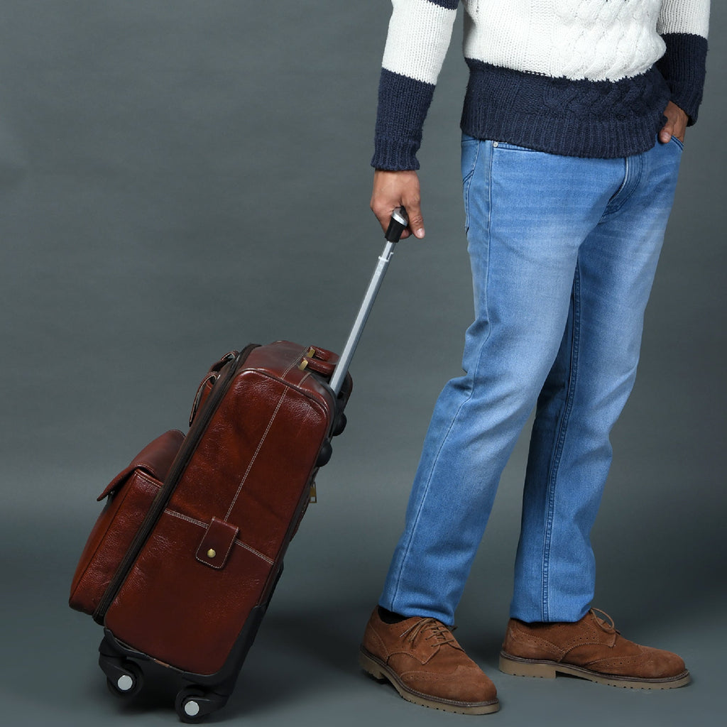 Brown leather carry-on trolley bag in motion with retractable handle and caster wheels