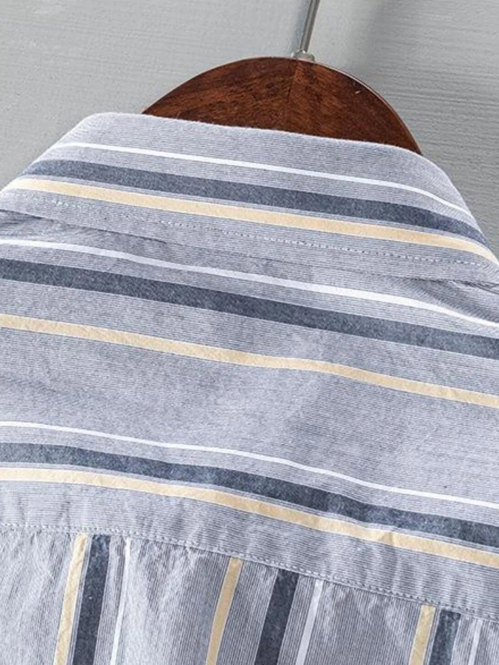 Close-up of light gray striped shirt collar and upper chest yoke detail.