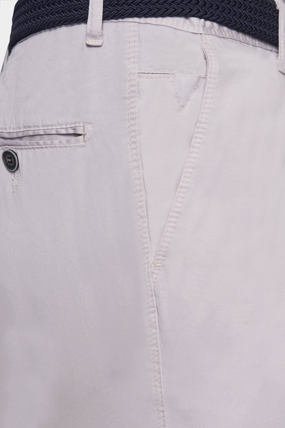 Off-white chino fabric close-up with pocket opening and topstitching