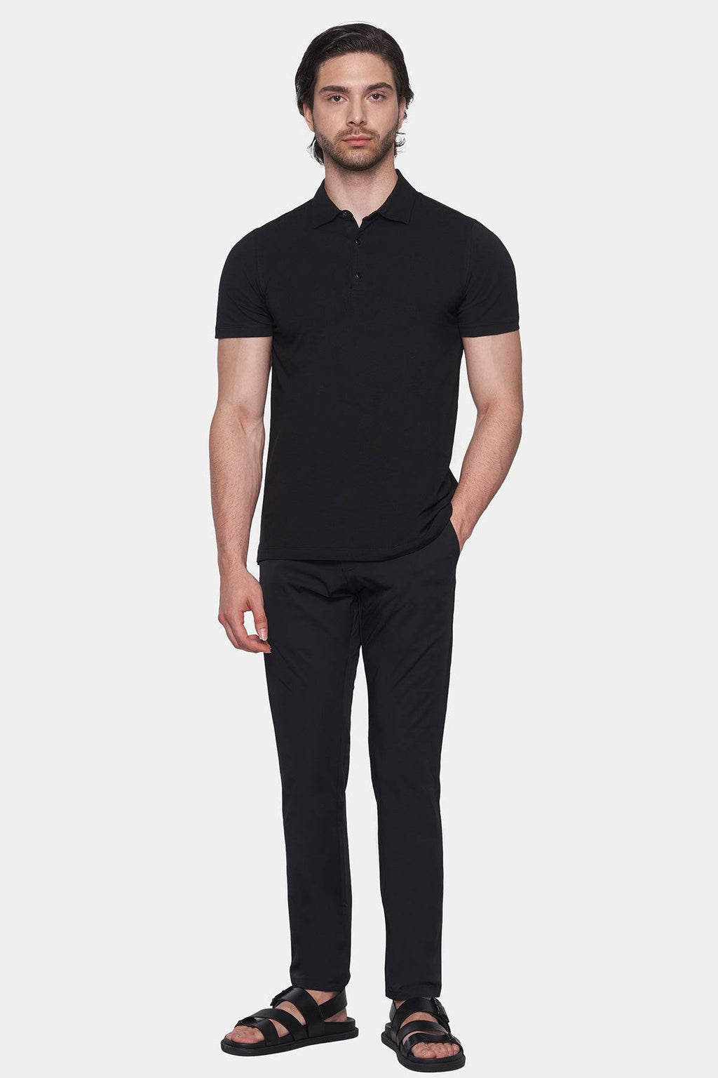 Black polo shirt on model, short sleeves, button placket, straight hem