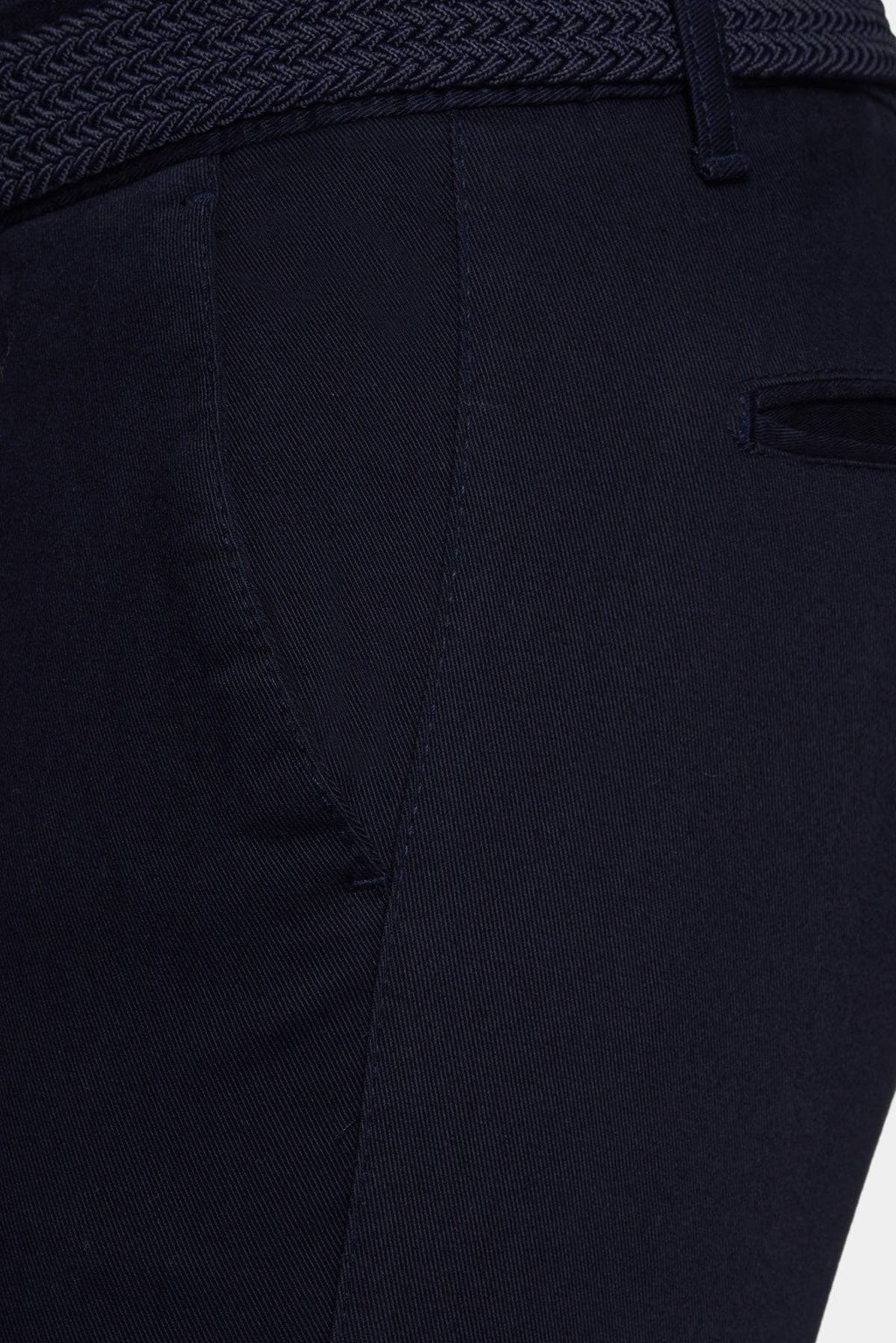 Navy chino close-up showing zipper fly, front seam, and pocket stitching