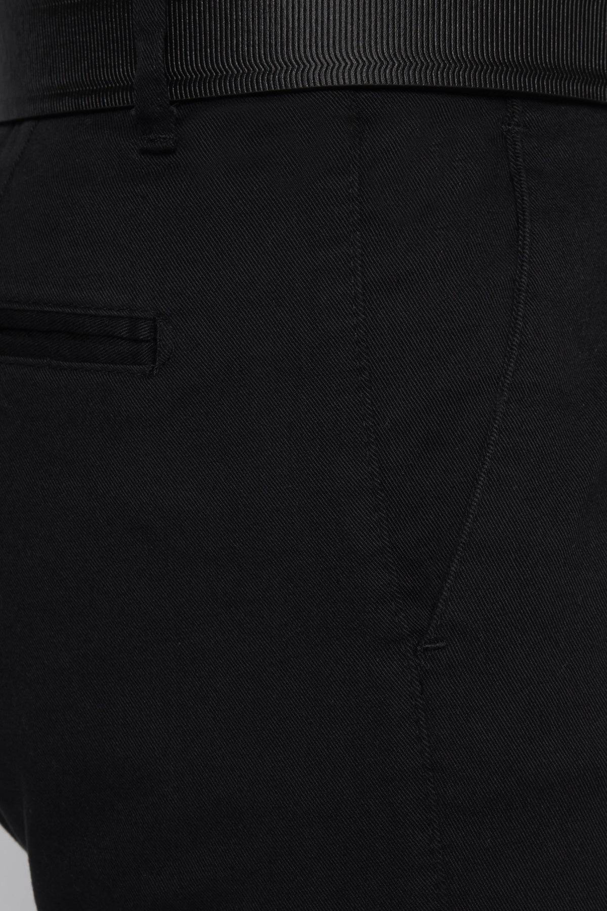 Black chino fabric close-up showing stitched seam and front pocket