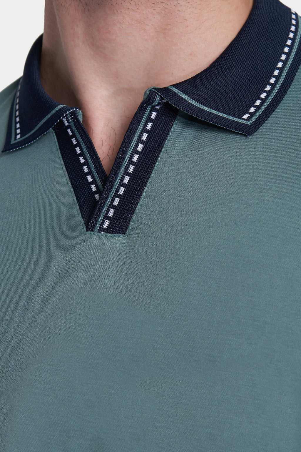 Racing green open polo placket with navy V-stitch and contrast collar trim