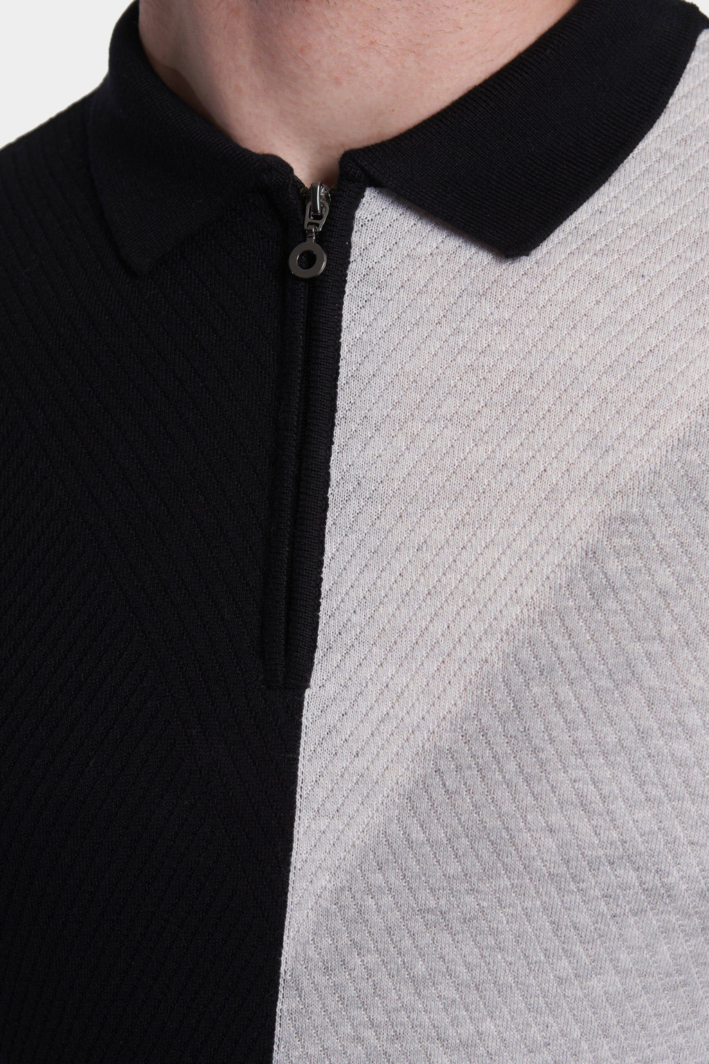 Detail of zip front polo: ribbed black placket and textured heather gray body
