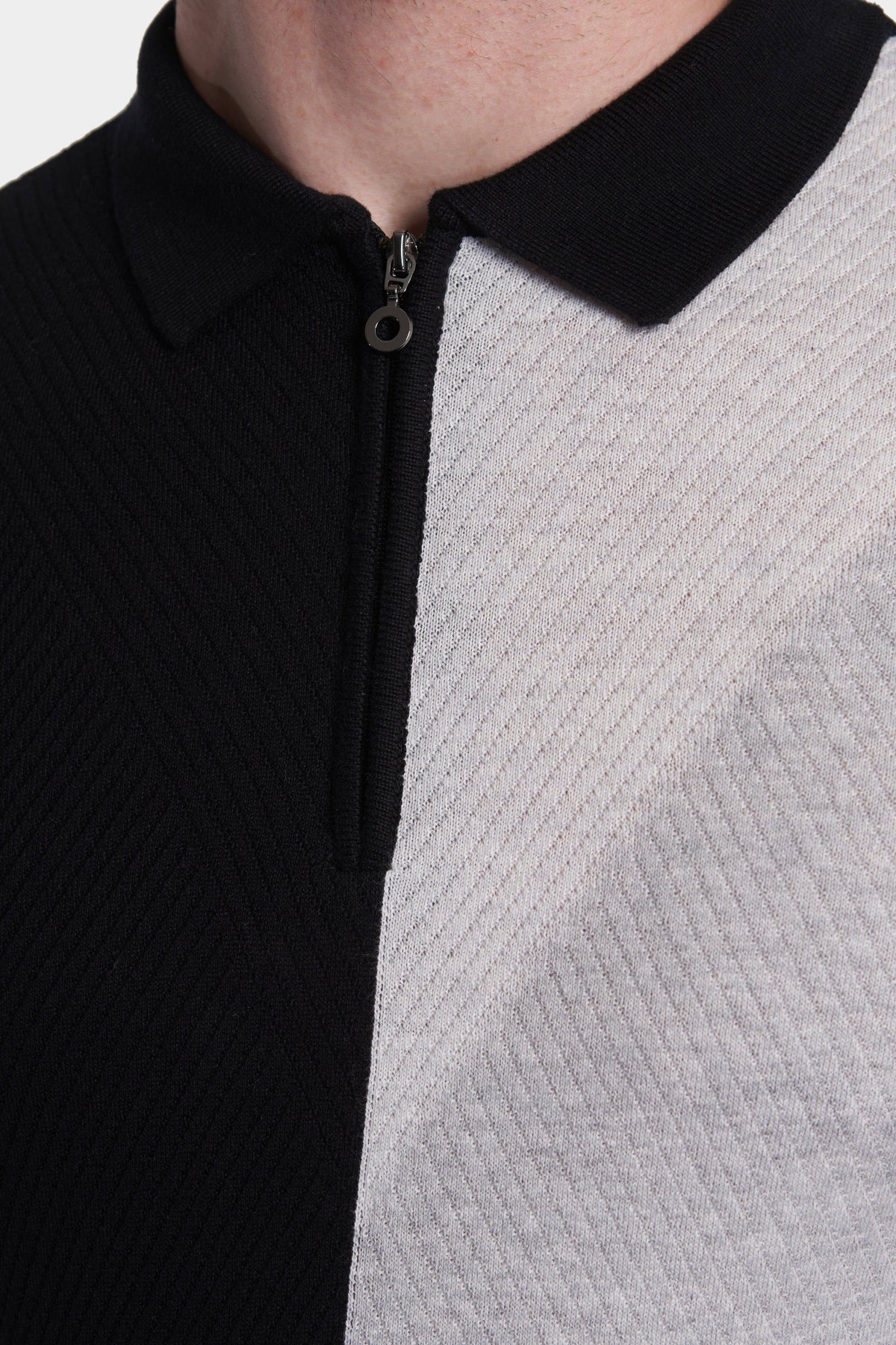 Detail of zip front polo: ribbed black placket and textured heather gray body