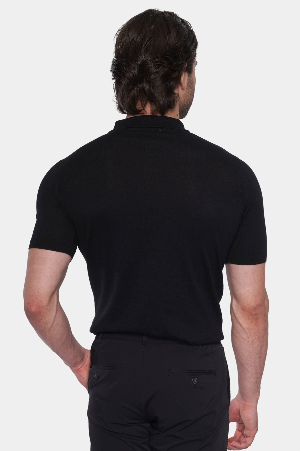Back view of black knit cotton polo with short sleeves and ribbed collar