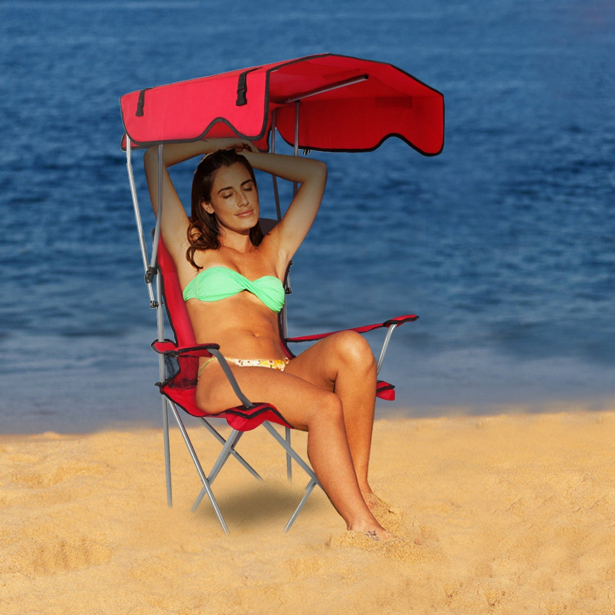 Red folding beach chair with sun canopy and padded seat for outdoor lounging