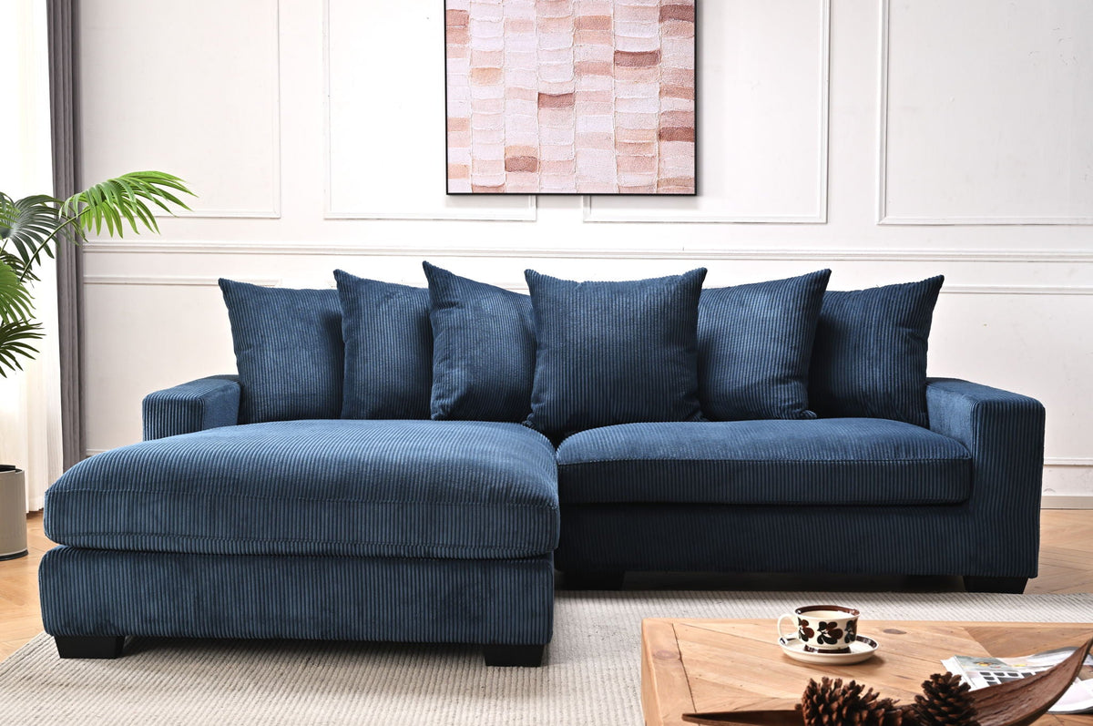Blue L-shaped sectional sofa with chaise, multiple throw pillows and textured upholstery.