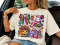 LF coquette ghost graphic tee, cream shirt with colorful bows, hearts, and ghost print