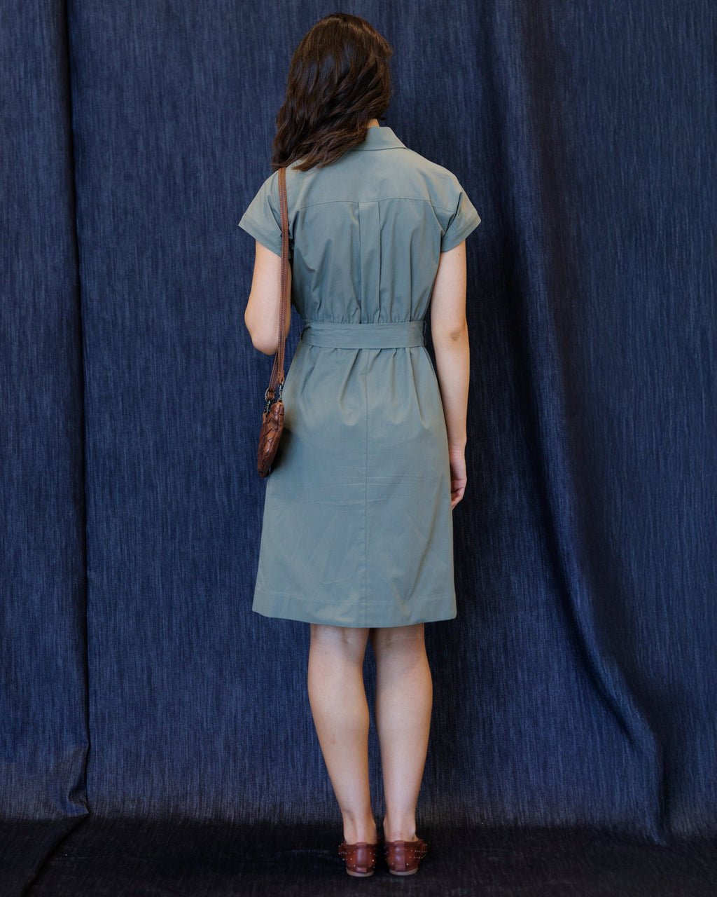 Back view of button-front cap-sleeve dress with tie waist, sage blue