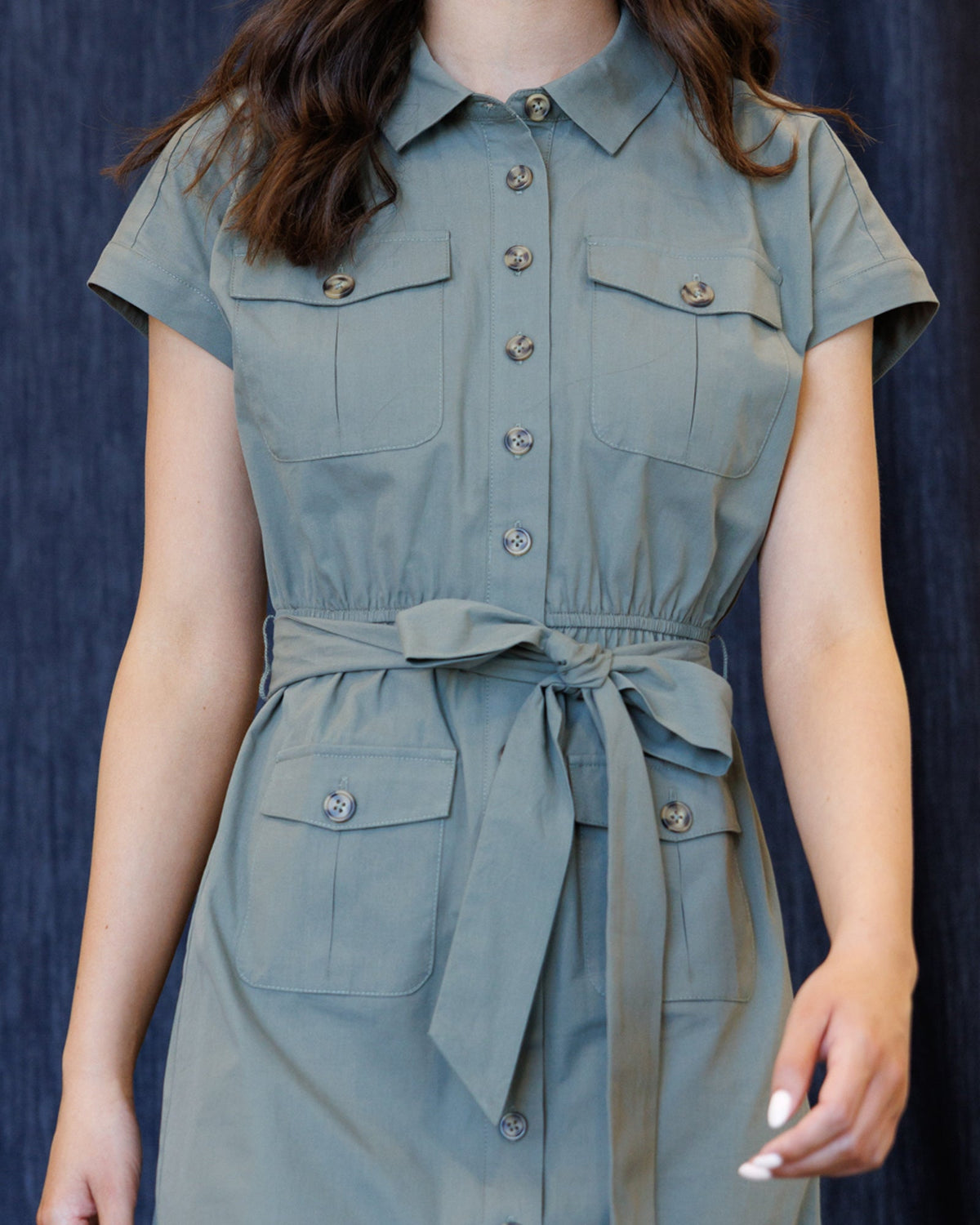 Close-up of sage blue dress: front buttons, chest pockets, tie waist detail
