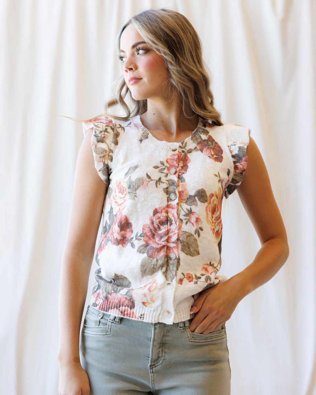 Cream floral sleeveless cardigan with button front and ruffled armhole detail