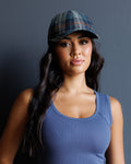 Plaid newsboy hat in blue, orange, and dark tones with curved brim