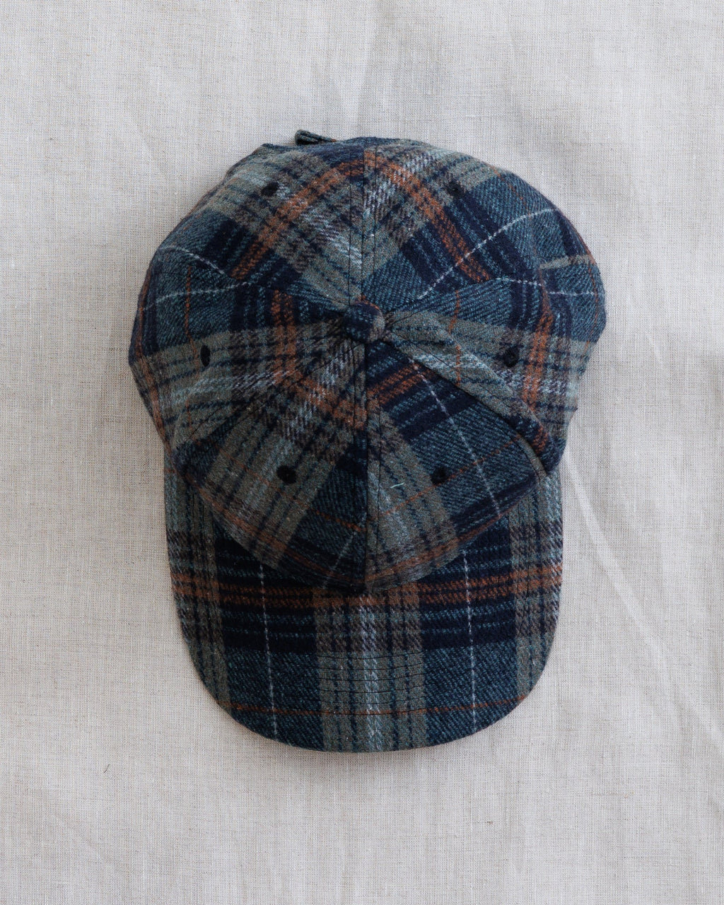 Plaid newsboy hat top view with bow-style crown and curved brim