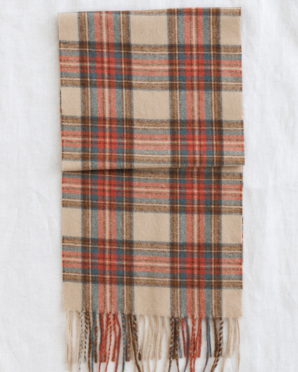 Plaid scarf in beige, rust, and muted teal with fringed ends