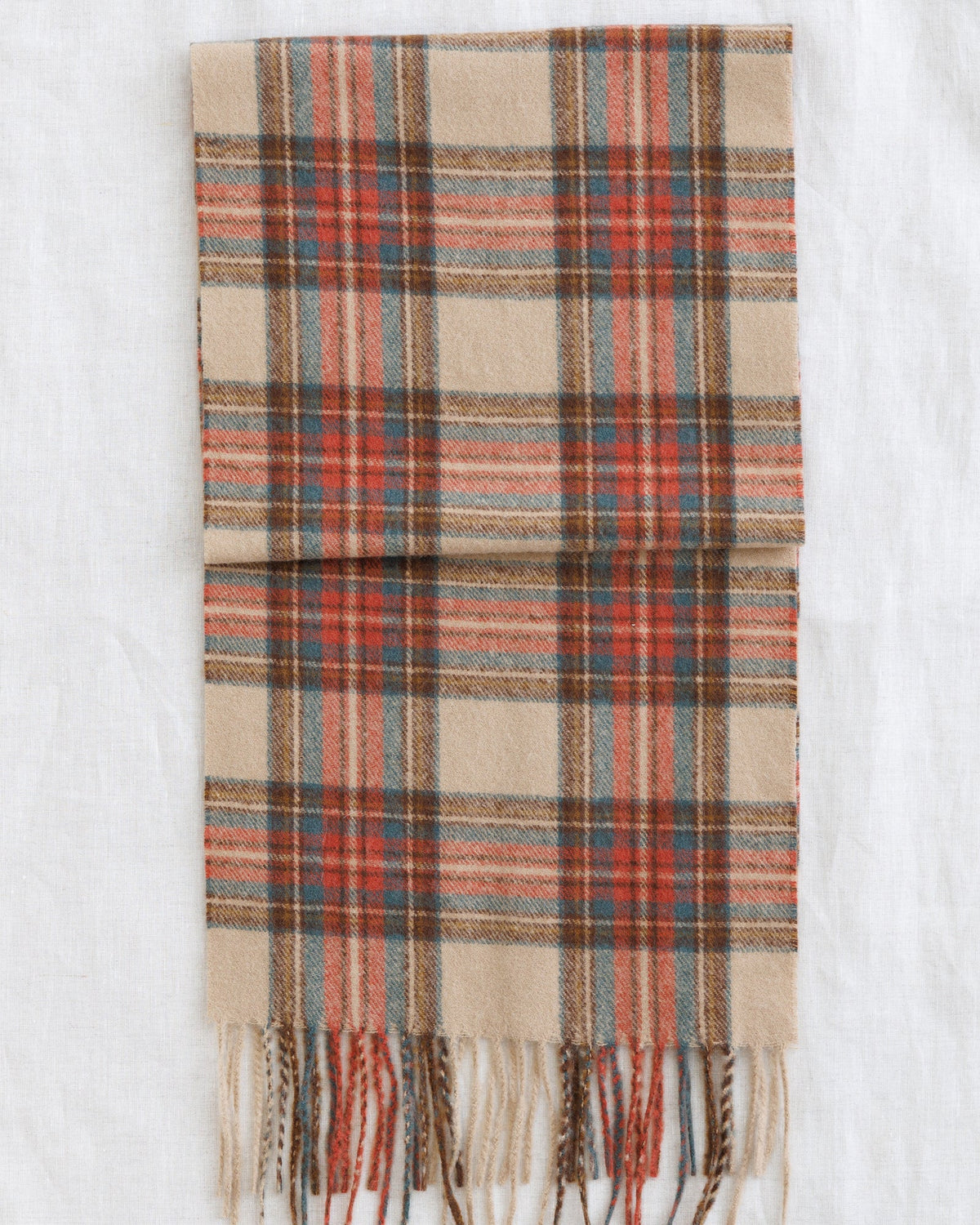 Plaid scarf in beige, rust, and muted teal with fringed ends