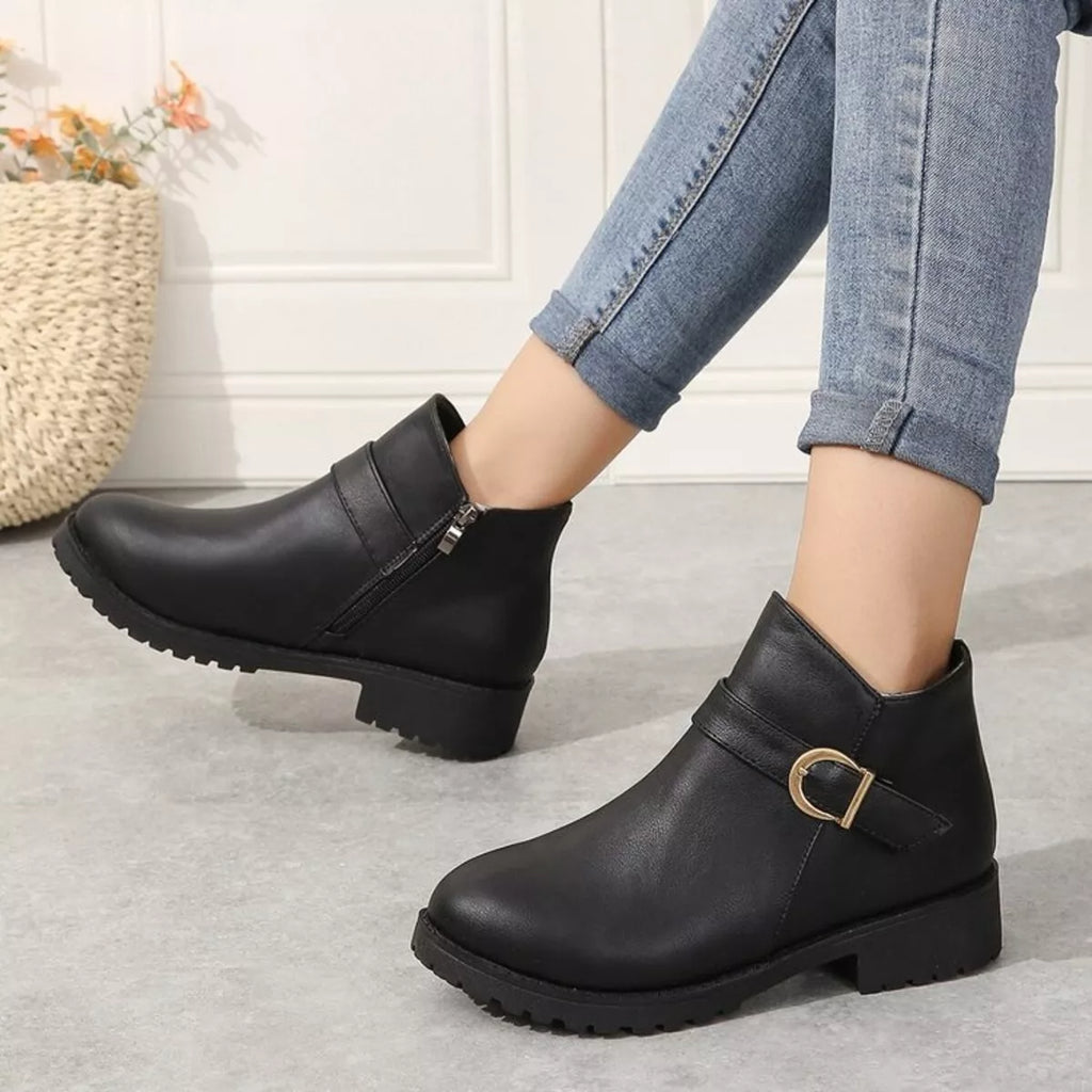 Black ankle boots with side zipper and gold buckle accent, thick lug outsole