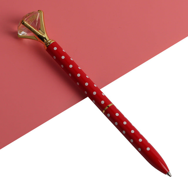 Red ballpoint pen with white dots and faceted gold gem top, metal tip