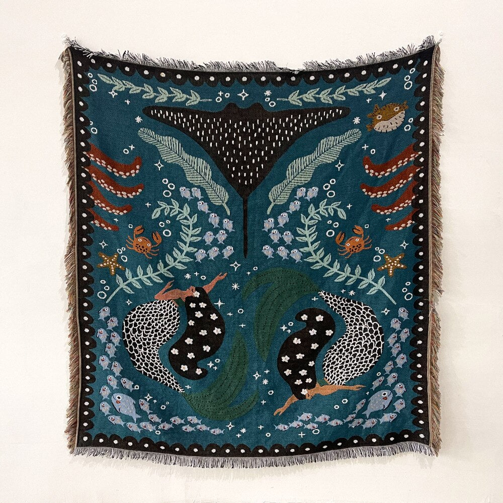 Navy celestial beach blanket with teal leaf and sea-creature eye motifs and fringe