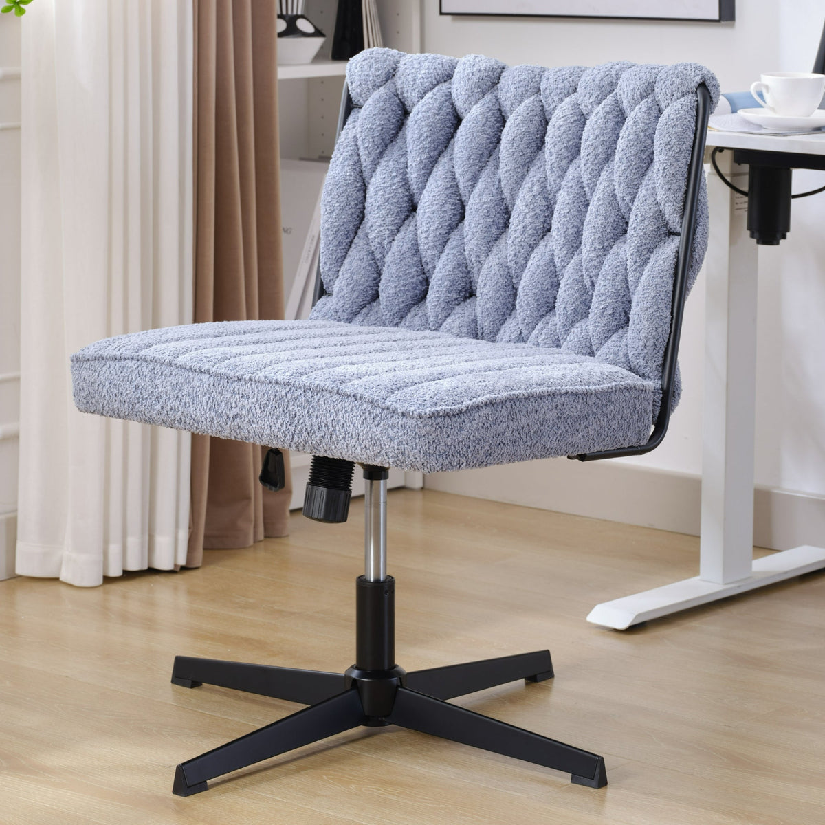 Blue armless office desk chair with tufted backrest and cushioned seat, black base