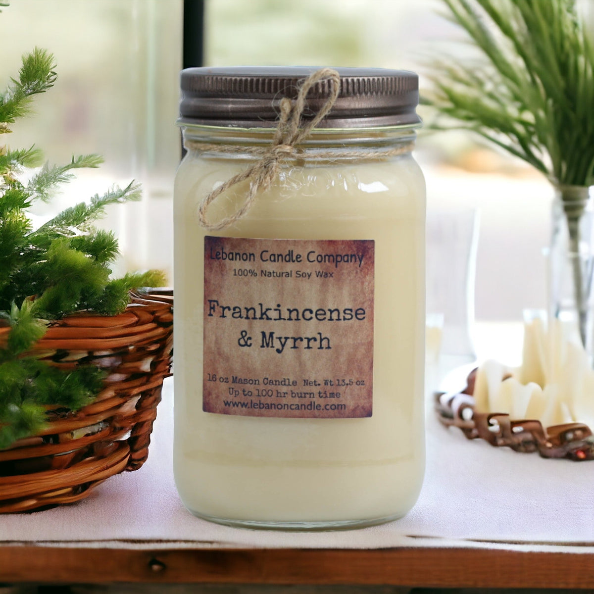 Clear jar soy candle with twine tie and Frankincense & Myrrh label on tabletop