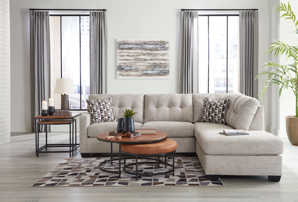 Light gray sectional sofa with corner chaise, decorative pillows, and chaise seat