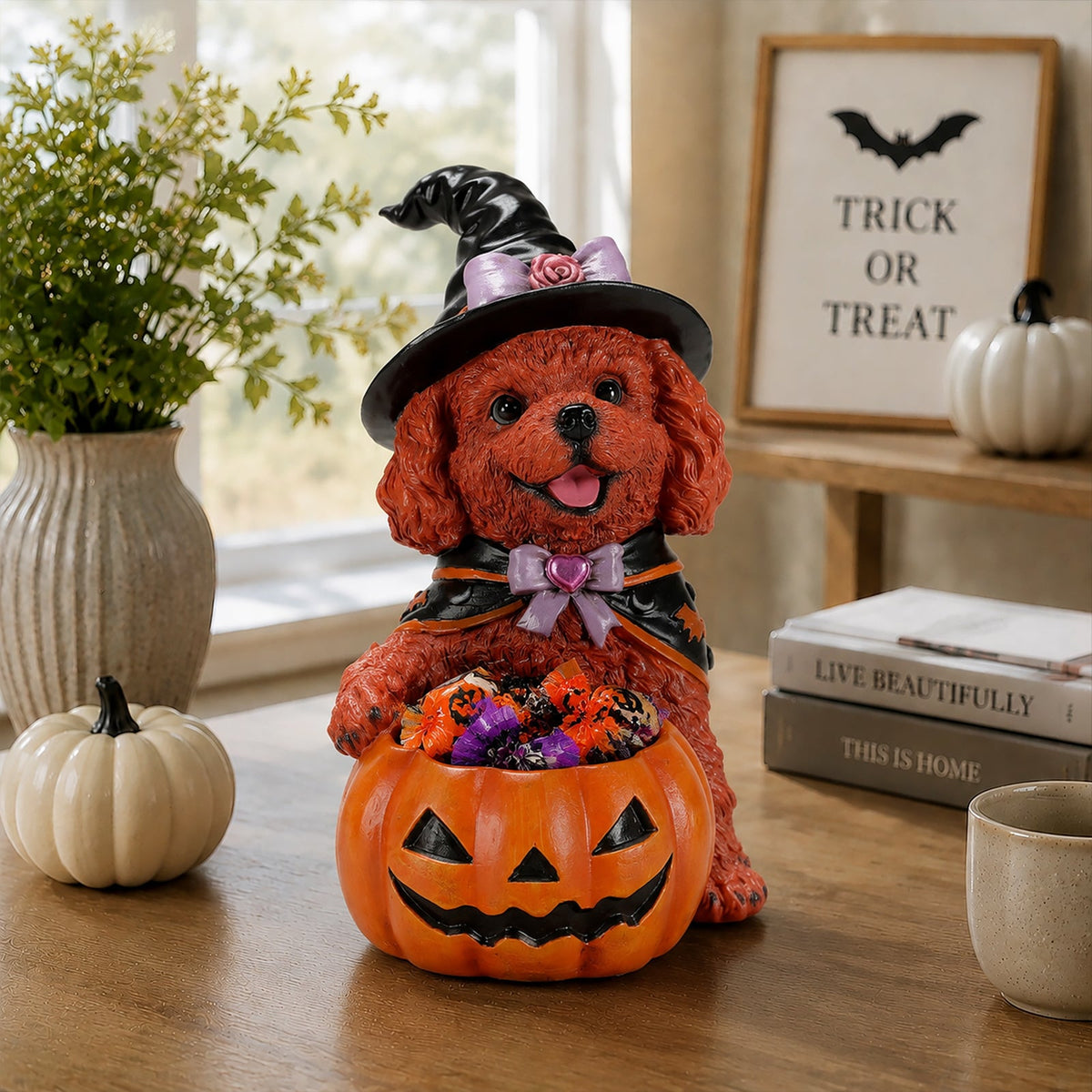 Brown teddy dog witch figurine holding a candy-filled jack-o'-lantern bowl