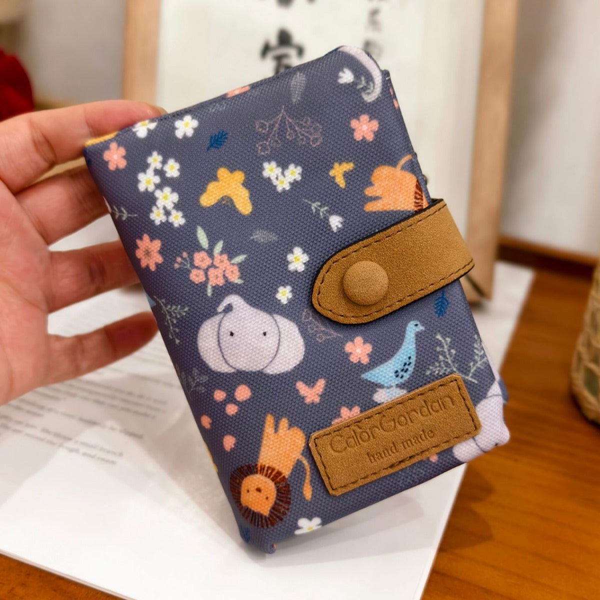 Printed tri-fold wallet with snap button, dark blue pet paw pattern, tan leather trim