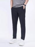 Men's slim-fit casual pants in black, tapered legs with belt loops and side pockets