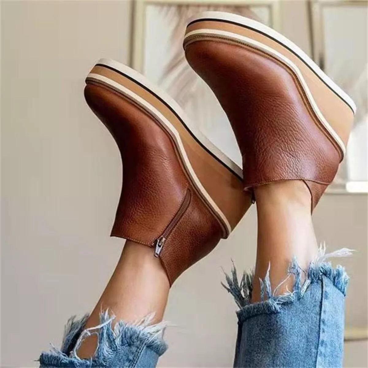 Brown ankle wedge boots with striped platform sole and side zipper