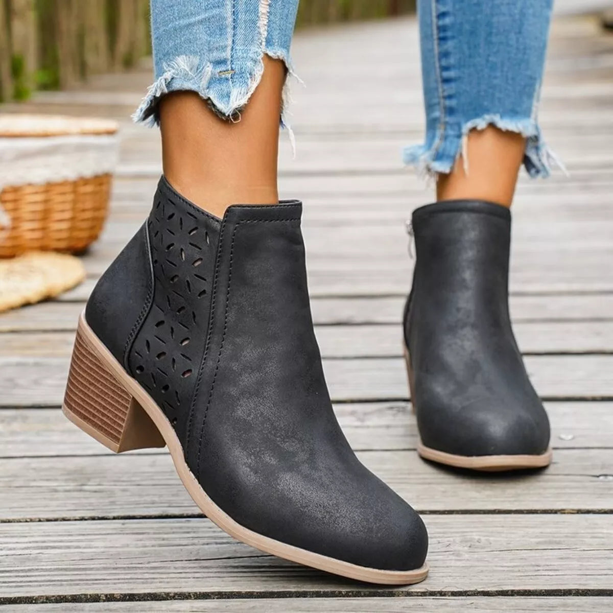 Black ankle boots with block heel, side cutout perforations, and pull-on panel