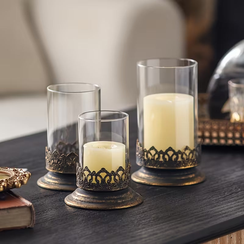 Set of 3 glass candle holders with clear cylinders and dark metal filigree base