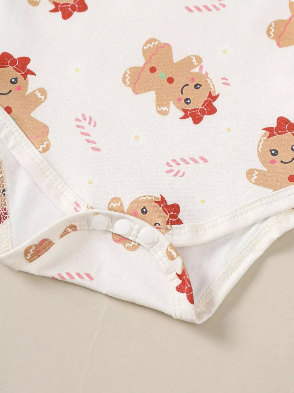 White bodysuit with gingerbread character print and snap-button bottom