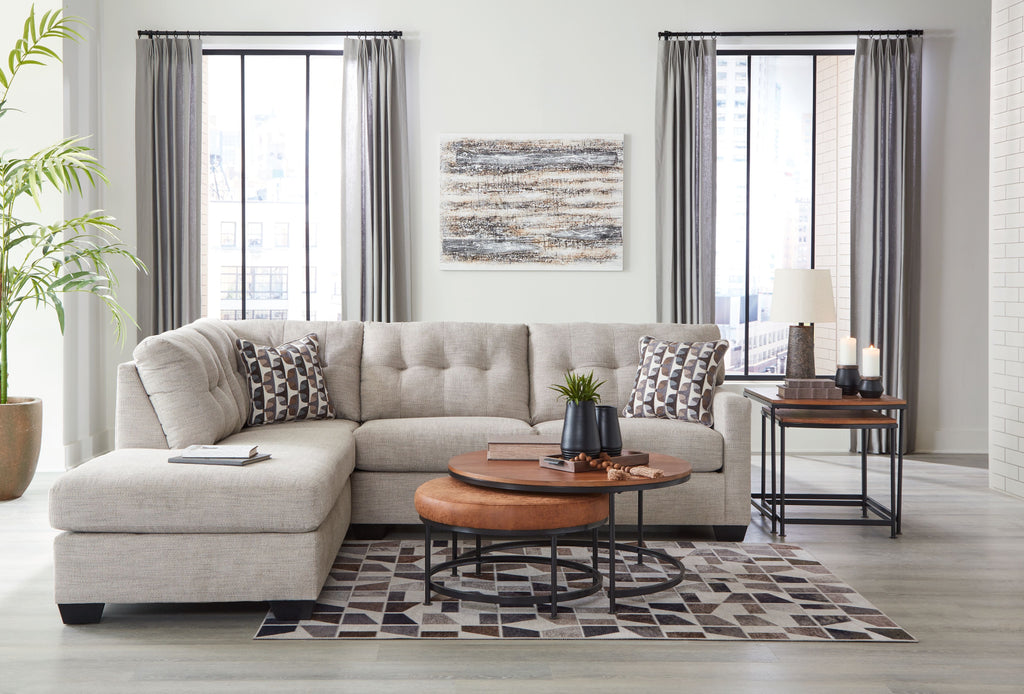 Light gray sectional sofa with corner chaise and patterned pillows on the cushions