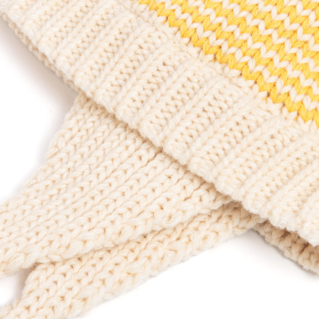 Close-up of yellow-striped knit earflap beanie with ribbed texture and ties.