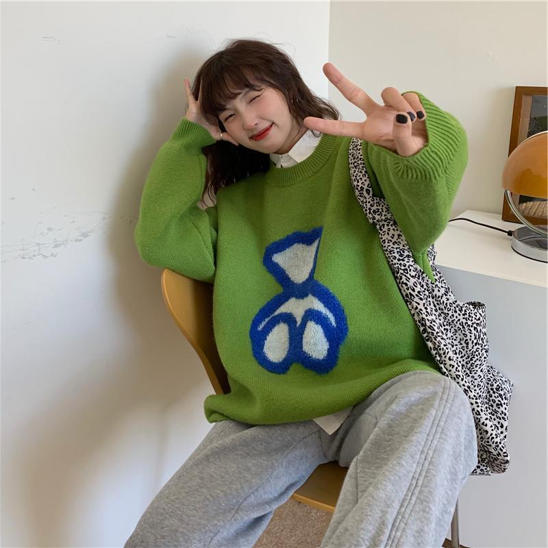 Women’s green knit sweater with long sleeves and blue heart graphic