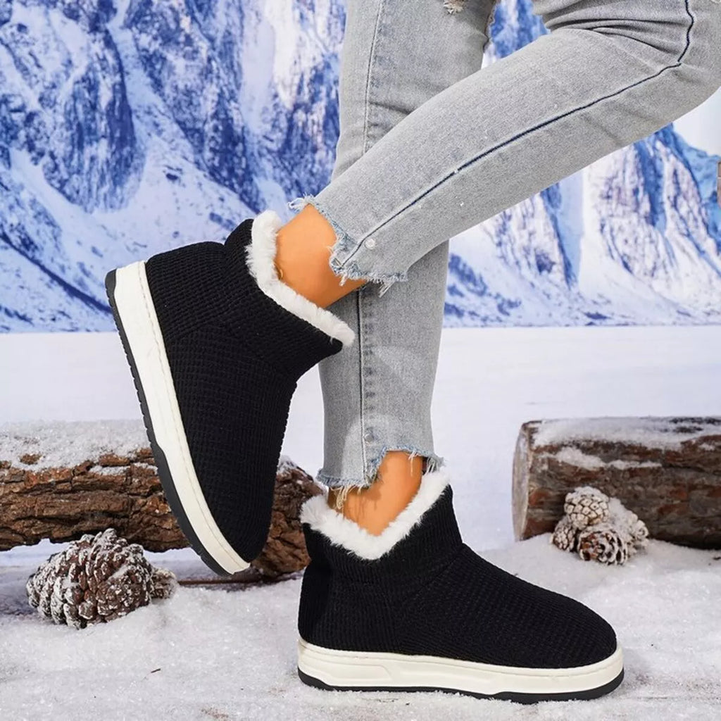 Black knit ankle boots with plush white collar and textured rubber sole
