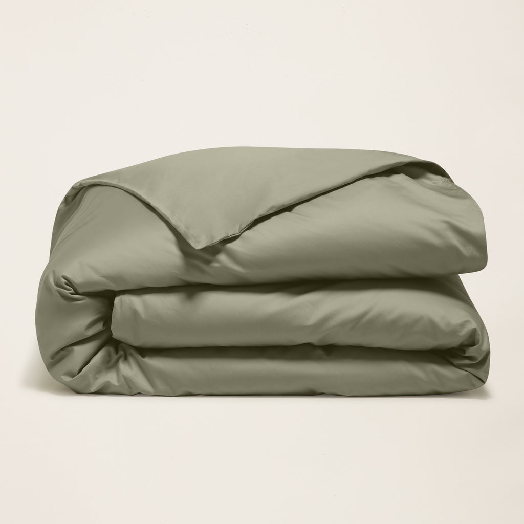 Folded moss green sateen duvet cover bundle with smooth, lustrous fabric folds
