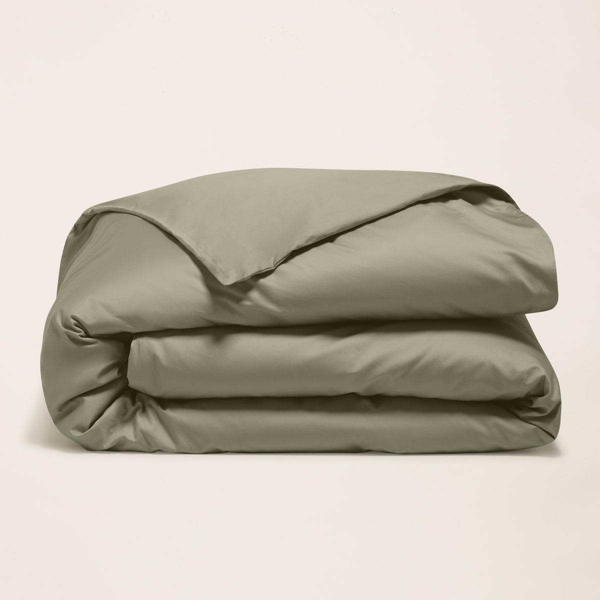 Folded moss green sateen duvet cover bundle with smooth, lustrous fabric folds