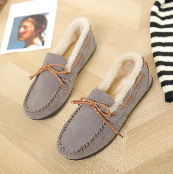 Grey plush moccasin flats with tan lace-up ties and fluffy interior lining